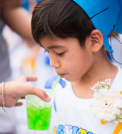 Little boy graduated at kindergarten school drinking waterの写真素材