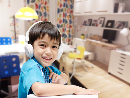 Little boy with headset doing homework in the roomの写真素材