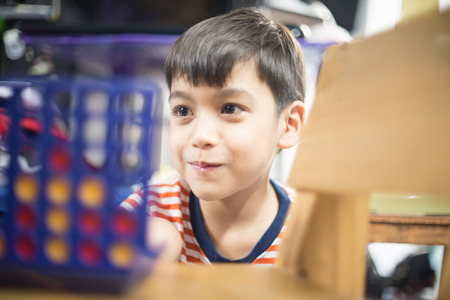 Little boy playing connect four game soft focus at eye contactの写真素材