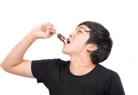 Asian man eating ice cream on white backgroundの写真素材