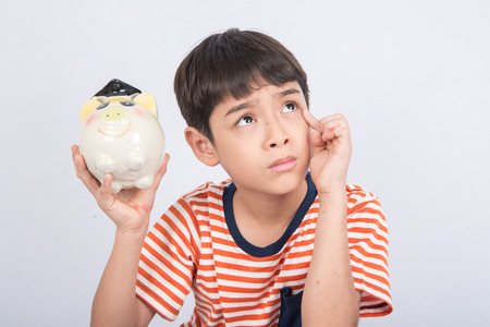 Little boy taking hammer trying to broke piggy bankの写真素材