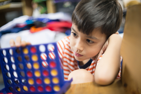 Little boy playing connect four game soft focus at eye contactの写真素材