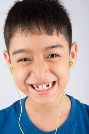 Little boy smiling using earphone headset listen the musicの写真素材