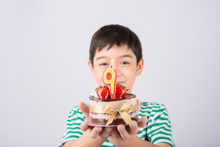 Little boy blowing candle on the cake for his birthdayの写真素材