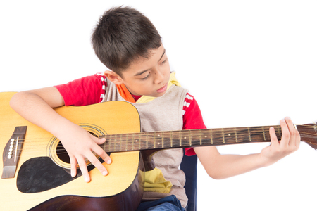Little boy playing classic guitar on white backgroundの写真素材