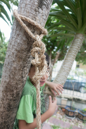 Kid climbing on the tree with rope net outdoor activityの写真素材