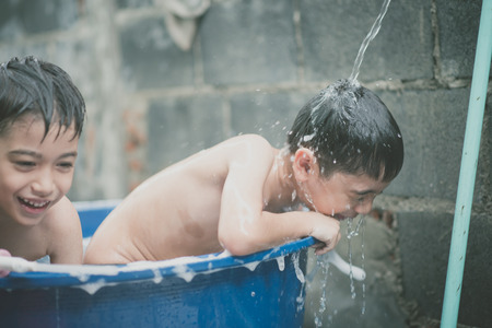 Little boy playing water splash at the backyard outdoor activities summer warm timeの写真素材