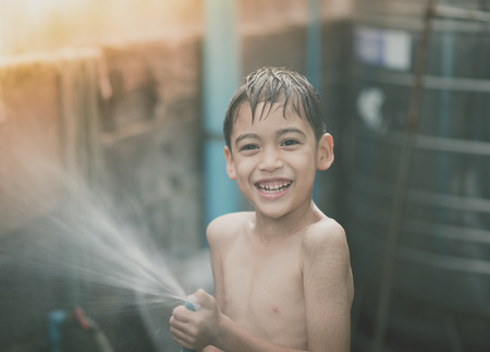 Little boy playing water splash at the backyard outdoor activities summer warm timeの写真素材