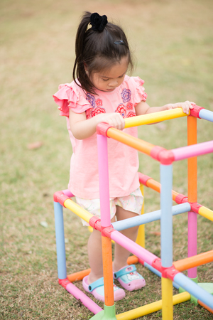 Close up little asian girl playing at playground with happy and smileの写真素材