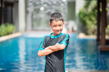 Little mix Asian Arab boy swimming at swimming pool in the hotel outdoor activityの写真素材
