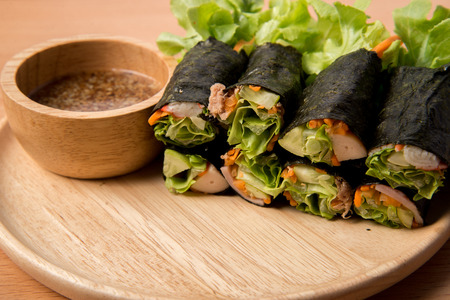 Salad roll mix on wooden dish with sasemi sauceの写真素材