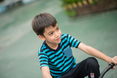 Little boy riding bicycle on the road around the houseの写真素材