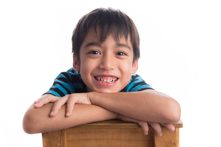 Little boy sitting on the wood chair on white backgroundの写真素材