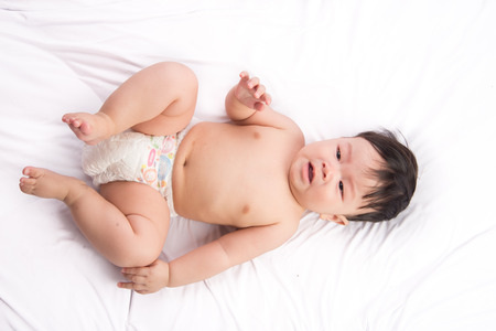 Portrait of cute Little asian boy 6 months old on the white bedの写真素材