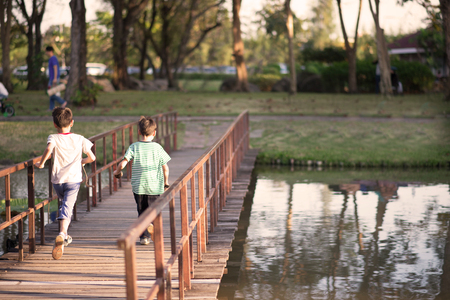 Little boy walking over the bridge in the parkの写真素材