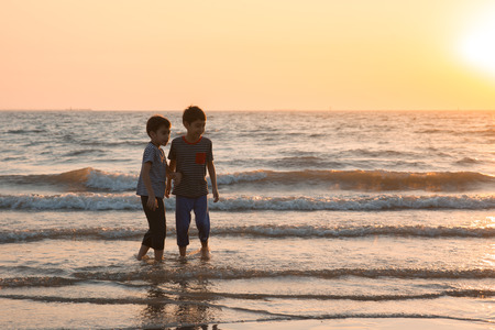 Little boy playing at the beach sunsetの写真素材