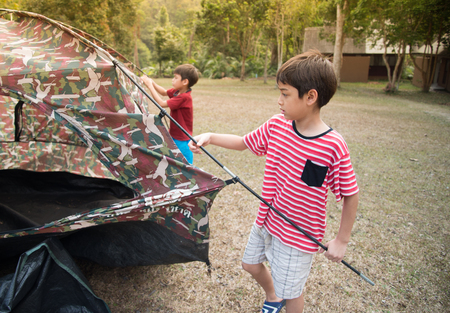 Little boy building a tent for camping with family holiday summer timeの写真素材