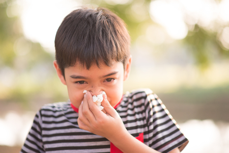 Little boy using tissue from allergy infection in the parkの写真素材