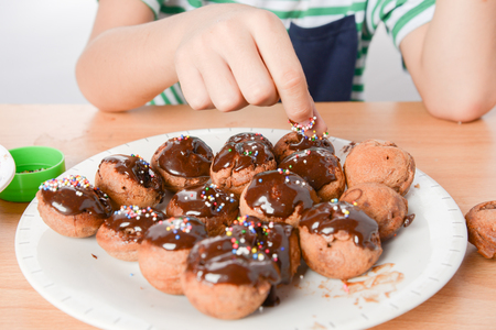Little boy cooking and eating chocolate cake home madeの写真素材