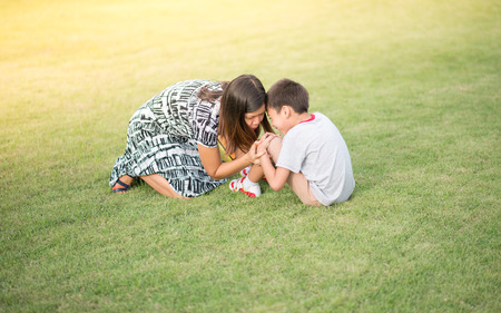 Singlemom mother talking care of son after an accident in the parkの写真素材