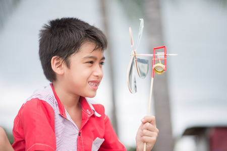 Little boy playing turbine wind toy at the beachの写真素材