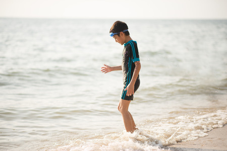 Boys and father playing together in the life ring at the beachの写真素材