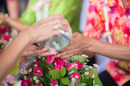 The younger traditionally sprinkle water onto their parents' and grandparents' handsの写真素材