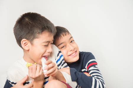 Little sibling boy brothers checking there high  tall each otherの写真素材