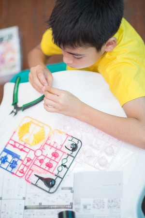Little boy build model kits toy depicting the vehicles and characters of the fictionalの写真素材