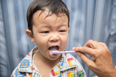 Grand mother's hand brush teeth for baby boy toddler morning timeの写真素材