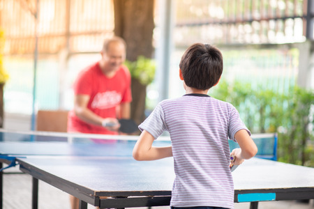 Kid playing table tennis outdoor with familyの写真素材