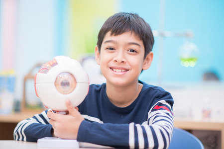 Little boy in the science library learning the model and bookの写真素材