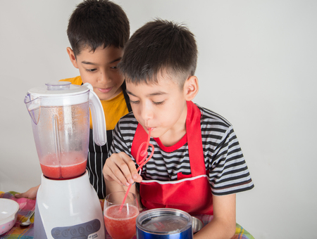 Little boys blend water melone juice by using blender at homeの写真素材