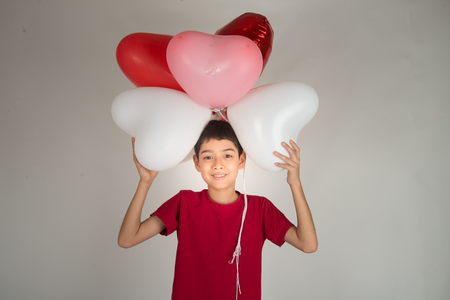 Boy  sibling with balloon  heart shape of loveの写真素材