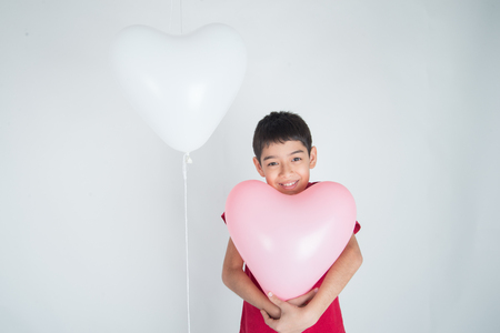 Boy  sibling with balloon  heart shape of loveの写真素材