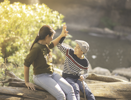 Mother and son hug each other happy together in the forest