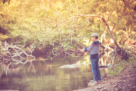Little Asian boy fishing at the river vintage  retroの写真素材
