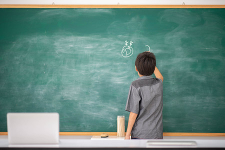 Student boy writing on the board about earth day save the world