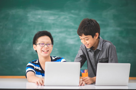 Asian students boy using laptop learning in the classroom at schoolの写真素材