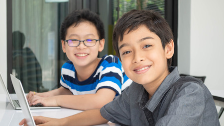 Asian students boy using laptop learning in the classroom at schoolの写真素材