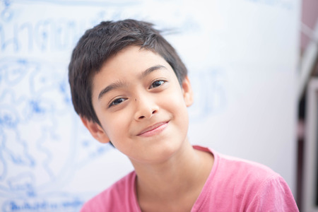 Little boy drawing eart on the whiteboard in the roomの写真素材