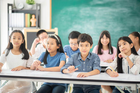 Asian primary student and teacher in the classroomの写真素材