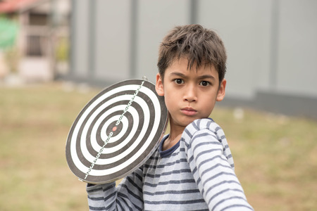 Little boy playing darts board family outdoor activityの写真素材