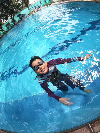 Little boys swimming and diving at the pool under water shotの写真素材