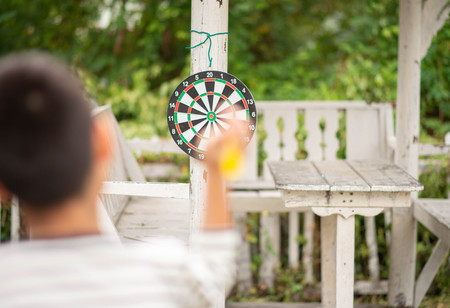 Little boy playing darts board family outdoor activityの写真素材