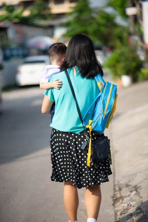 Little toddler boy cry, first day at school kindergarten with motherの写真素材