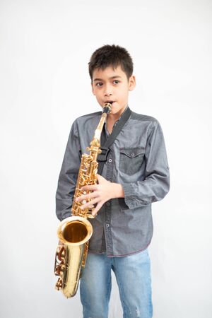 Little asian musician boy playing saxophone instrumentの写真素材