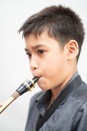 Little asian musician boy playing saxophone instrumentの写真素材