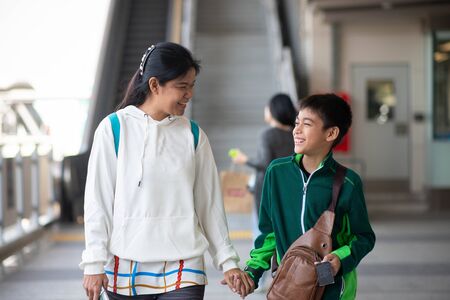 Little boy buying electric ticket and walking in the public skytrain station with familyの写真素材