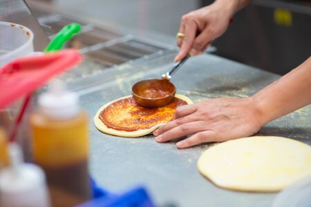Worker making pizza in the restaurantの写真素材